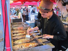 Sur son étal du marché de nuit de Richmond, le cuisinier Navy Zhang propose des poissons grillés entiers à la vente.