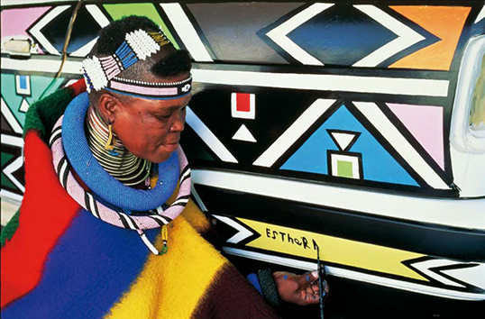 Esther Mahlangu signe la BMW qu’elle vient de peindre.